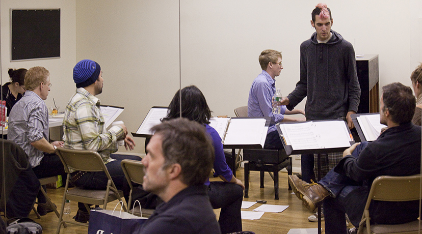 Jeb Brown (foreground), composer Kyle Jarrow (at piano), music director Nathan Leigh (standing) and the company in rehearsal